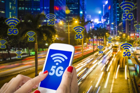 Digital composite of 5G , a woman hand using smartphone with blurry modern city on the background. Hong Kong busy city and High speed mobile web technology concept.