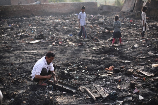 epa06674462 Rohingya refugees look for their belongings after a fire broke out in their makeshift settlement in Madanpur Khadar, in New Delhi, India, 17 April 2018. According to news reports, around 50 shanties were gutted in a fire that broke out in the makeshift settlement of Rohingya Refugees living in Madanpur Khadar in Delhi on 15 April 2018. There are around 50 Muslim Rohingya families living in the makeshift housing, having fled Myanmar, provided by the NGO Zakat Foundation of India. Most of the refugees living in this area work where they can on day rates or as ragpickers and earn about five US dollars per day.  EPA-EFE/RAJAT GUPTA