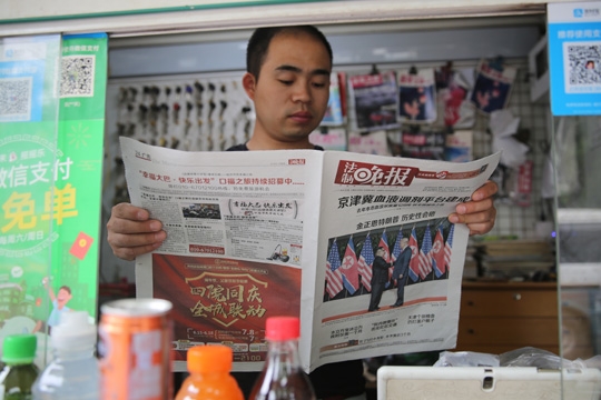 epa06803683 A Chinese man looks at a newspaper reporting about the summit between US President Donald J. Trump and North Korean leader Kim Jong-un during their historic meeting in Singapore; in Beijing, China, 13 June 2018. The summit marked the first meeting between an incumbent US President and a North Korean leader.  EPA-EFE/WU HONG