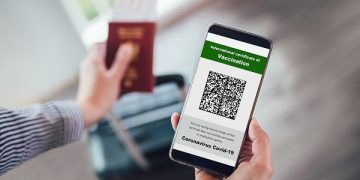 Vaccination, disease immunity passport, health and surveillance concepts. Smartphone displaying a valid digital vaccination certificate for COVID-19