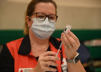 210109-N-OX321-2038 NAVAL AIR STATION SIGONELLA, ITALY (Jan. 9, 2021)-- Angeline Mitchell, registered nurse and American Red Cross volunteer, prepares shots of the Moderna COVID-19 vaccine for the inoculations of critical medical staff and first responder volunteers onboard Naval Air Station (NAS) Sigonella, Jan. 9, 2021. NAS Sigonella’s strategic location enables U.S., allied, and partner nation forces to deploy and respond as required to ensure security and stability in Europe, Africa and Central Command. (U.S. Navy photo by Mass Communication Specialist 1st Class Kegan E. Kay)..