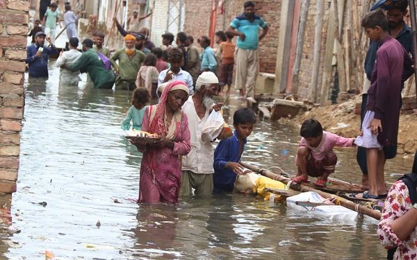 epa10092329 People affected by monsoon rains receive free food distributed by Saylani welfare International Trust in Hyderabad, Pakistan, 26 July 2022. Heavy rains have claimed 310 lives so far in Pakistan during the current monsoon season. According to chief meteorologist, the third monsoon system will penetrate parts of the country.  EPA-EFE/NADEEM KHAWAR