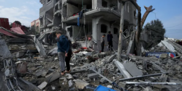 Палестинците ги проверуваат урнатините на зградата на семејството Ал Навасра уништена во израелски напад во бегалскиот камп Магази, 25 декември [Адел Хана/АП Фото]