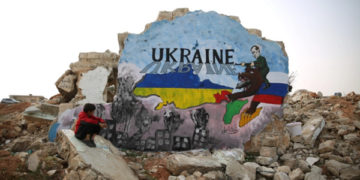 A Syrian artist in the countryside of Idlib painted a mural of solidarity with the Ukrainian people on the remaining wall of a house destroyed by Russian warplanes [Ali Haj Suleiman/Al Jazeera]