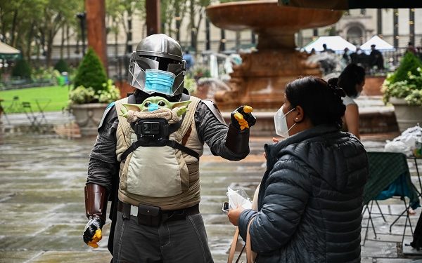 HANDOUT IMAGE: The Maskalorian gives out masks to a stranger in New York City. 
(Chad Nicholson)