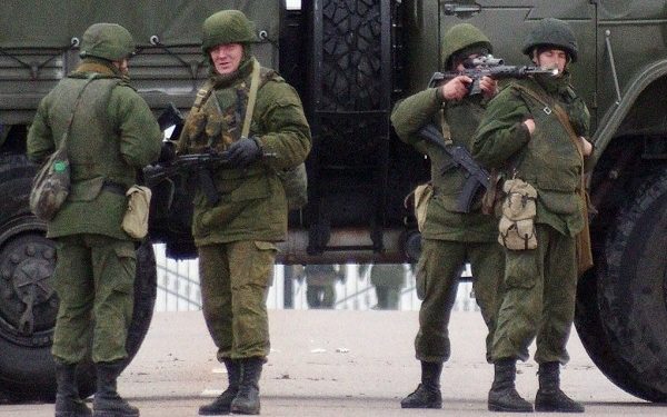 Unidentified soldiers block a road to Ukrainian military airport Belbek not far from Sevastopol on February 28, 2014. Ukraine accused Russia of staging an "armed invasion" of Crimea on Friday and appealed to the West to guarantee its territorial integrity after pro-Moscow gunmen took control of the peninsula's main airport. Unidentified armed men were patrolling outside of Crimea's main airport early Friday while gunmen were also reported to have seized another airfield on the southwest of the peninsula where ethnic Russians are a majority and where pro-Moscow sentiment runs high.   AFP PHOTO/ VASILIY BATANOV        (Photo credit should read Vasiliy BATANOV/AFP via Getty Images)