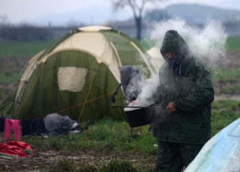 A migrant caring a hot water at a refugee camp, at the border between Greece and the Former Yugoslav Republic of Macedonia (FYROM)  near Idomeni, northern Greece, 15 March 2016. Greece has registered in its territory more of 44,000 migrants trapped due to entry restrictions already imposed by Macedonia in recent months, by denying entry to all those who are considered economic migrants, prohibiting the passage of Afghans, and finally denying entry to all Syrians and Iraqis who are not from combat areas.