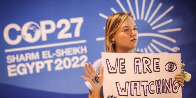 epa10314533 An activist holds a sign during a demonstration encouraging world leaders to maintain policies that limit warming to 1.5 degrees Celsius since pre-industrial times and provide reparations for loss and damage at the 2022 United Nations Climate Change Conference (COP27), in Sharm El-Sheikh, Egypt, 19 November 2022. The 2022 United Nations Climate Change Conference (COP27), runs from 06 to 18 November, and is expected to host one of the largest number of participants in the annual global climate conference as over 40,000 estimated attendees, including heads of states and governments, civil society, media and other relevant stakeholders will attend. The events will include a Climate Implementation Summit, thematic days, flagship initiatives, and Green Zone activities engaging with climate and other global challenges.  EPA-EFE/SEDAT SUNA