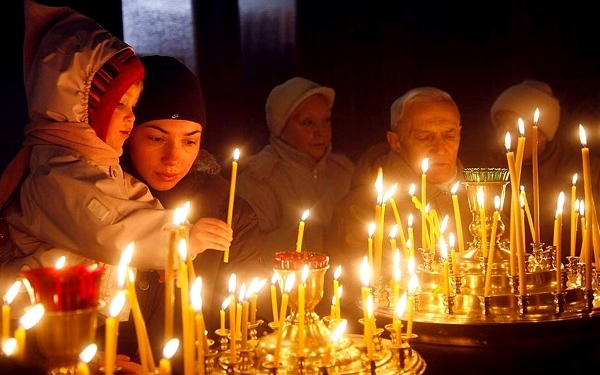 People light candles in a church  to mark the Orthodox Christmas in Kiev, Ukraine, Friday, Jan. 7, 2011.  Christmas falls on Jan. 7 for Orthodox Christians in the Holy Land, Ukraine and other Orthodox churches that use the old Julian calendar instead of the 16th-century Gregorian calendar adopted by Catholics and Protestants and commonly used in secular life around the world.(AP Photo/Efrem Lukatsky)