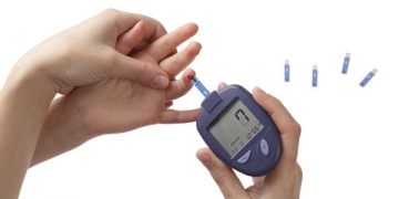 Woman checks glucose level in blood at the child