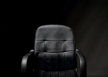 A detailed image of an empty, black, office chair