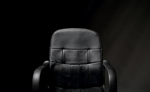 A detailed image of an empty, black, office chair