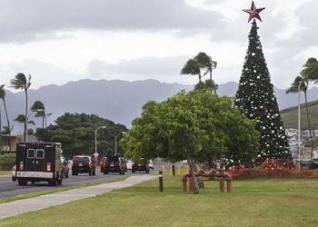 The motorcade carrying President Barack Obama passes a large Christmas tree on Marine Corps Base Hawaii as it takes the President to the gym, Tuesday, Dec. 23, 2014, in Kailua, Hawaii during the Obama family vacation. (AP Photo/Jacquelyn Martin)