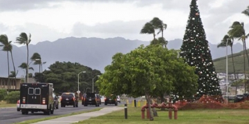 The motorcade carrying President Barack Obama passes a large Christmas tree on Marine Corps Base Hawaii as it takes the President to the gym, Tuesday, Dec. 23, 2014, in Kailua, Hawaii during the Obama family vacation. (AP Photo/Jacquelyn Martin)