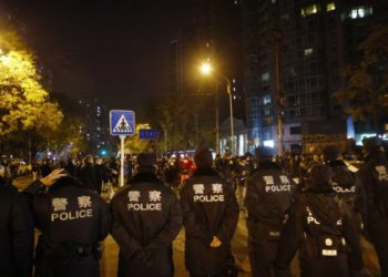 epa10332664 Police officers block a road during a protest triggered by a fire in Urumqi that killed 10 people in Beijing, China, 27 November 2022. Protests against’s China strict Covid restrictions have erupted in various cities including Beijing and Shanghai, triggered by a tower fire that killed 10 people Xinjiang’s capital, Urumqi.  EPA-EFE/MARK R. CRISTINO