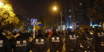 epa10332664 Police officers block a road during a protest triggered by a fire in Urumqi that killed 10 people in Beijing, China, 27 November 2022. Protests against’s China strict Covid restrictions have erupted in various cities including Beijing and Shanghai, triggered by a tower fire that killed 10 people Xinjiang’s capital, Urumqi.  EPA-EFE/MARK R. CRISTINO