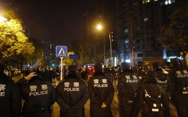 epa10332664 Police officers block a road during a protest triggered by a fire in Urumqi that killed 10 people in Beijing, China, 27 November 2022. Protests against’s China strict Covid restrictions have erupted in various cities including Beijing and Shanghai, triggered by a tower fire that killed 10 people Xinjiang’s capital, Urumqi.  EPA-EFE/MARK R. CRISTINO