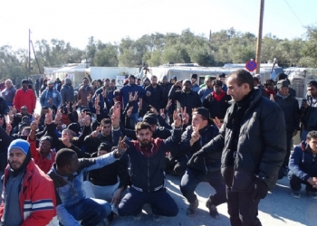epa05757460 Refugees protest by sitting down on a street outside the Moria refugee camp, following the recovery of a 45-year old male refugee dead body, near the port of Mytilene, on the island of Lesbos, Greece, 28 January 2016.  EPA/STR