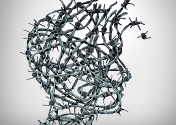 Anxiety solution and freedom from fear and escape from tortured thinking and depression concept as a group of tangled barbwire or barbed wire fence shaped as a human head breaking free as a metaphor for psychological or psychiatric icon.