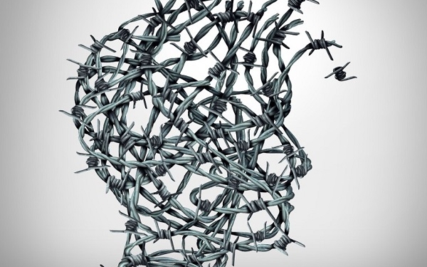 Anxiety solution and freedom from fear and escape from tortured thinking and depression concept as a group of tangled barbwire or barbed wire fence shaped as a human head breaking free as a metaphor for psychological or psychiatric icon.