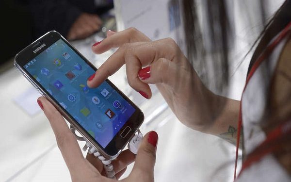 FILE - In this Feb. 25, 2014 file photo, theSamsung Galaxy S5 is displayed at the Mobile World Congress in Barcelona, Spain, Tuesday, Feb. 25, 2014.  Leading tech companies are increasingly nudging consumers to use their own fingers, faces and eyes as digital key to unlock phones and other gadgets. But there are downsides: Hackers could still steal your fingerprint, or its digital representation. And police may have broader legal powers to make you unlock your phone. (AP Photo/Manu Fernandez)