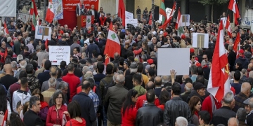epa07235413 Supporters of the Lebanese communist party along with activists from the civil society wave the party flags with Lebanese flags and placards during a protest in Beirut, Lebanon, 16 December 2018. Hundreds of protesters from the National Union of Trade Unions and Users in Lebanon, led by the Lebanese Communist Party and the Lebanese Democratic Youth Union, protested in front of the headquarters of the Banque du Liban and marched towards down town Beirut, rejecting unfair taxes on gasoline and value added (TVA) and all indirect taxes, calling on the government to protect citizens right to work and right to have access to medical care.  EPA-EFE/NABIL MOUNZER