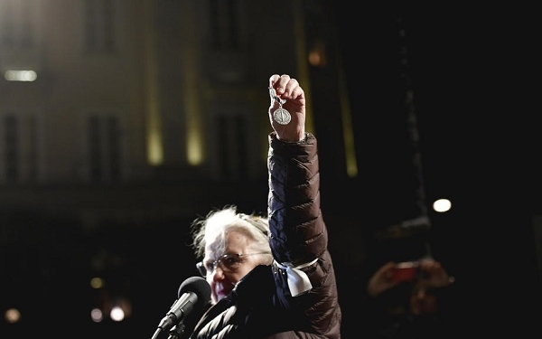epa08060515 Swedish physician Christina Doctare holds a medal she received while working for the UN peacekeeping forces in Bosnia in the 1990s, during a protest against the awarding of the 2019 Nobel literature prize to Peter Handke, in Stockholm, Sweden, 10 December 2019.  EPA-EFE/Stina Stjernkvist  SWEDEN OUT