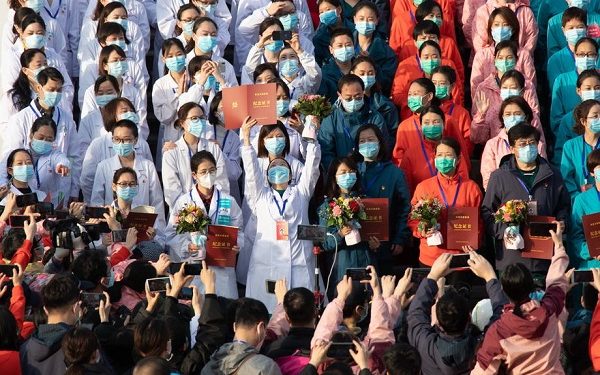 epa08285089 Medical staff celebrate after all patients were discharged at Wuchang Fangcang hospital, a temporary hospital set up at Hongshan gymnasium to treat people infected with the coronavirus and COVID-19 disease, in Wuhan, Hubei Province, China, 10 March 2020 (issued 11 March 2020). The temporary hospital closes on 10 March after China reported days of decline in the number of new coronavirus cases originating in the country. However, the number of coronavirus cases imported to China continued to rise, with 40 percent of the latest 24 infections reported on 11 March stemming from overseas.  EPA-EFE/YFC CHINA OUT