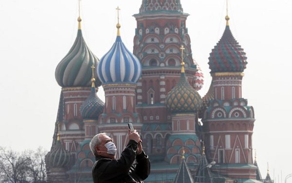 epa08330019 An elderly man wearing protective mask takes pictures in front of the cathedral of Vasily the Blessed on the Red Square in Moscow, Russia, 29 March 2020. Russian authorities recommended for all Russians do not leave their homes for nine days in order to stop the spread of the coronavirus Covid-19 disease. The next week was declared not working for evrebody, all restaurants, bars, shopping centers, cinemas and city parks were closed. According to the Russian Quarantine Service of Rospotrebnadzor (Russian Federal Service for Surveillance on Consumer Rights Protection and Human Wellbeing), eight people died and 1534 cases of the Covid-19 disease have been confirmed in Russia.  EPA-EFE/SERGEI ILNITSKY