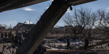 epa09815737 A police officer and a man carry on a destroyed bridge the dead body of a woman, who was allegedly killed by the Russian army, as residents flee from the frontline town of Irpin, Kyiv (Kiev) region, Ukraine, 10 March 2022. Thousands of residents are feeling Irpin and Bucha, as well as other settlements near Kyiv which were the most affected by the Russian army invasion.  EPA-EFE/ROMAN PILIPEY
