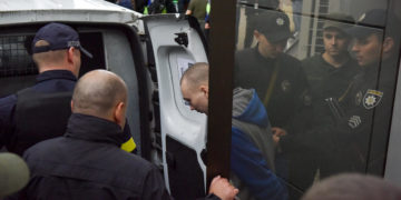 epa09968880 Russian serviceman Vadim Shishimarin (C) is escorted by police officers to a vehicle as he leaves after a court hearing in Kyiv, Ukraine, 23 May 2022. Russian serviceman Vadim Shishimarin, 21, was sentenced to life imprisonment for the killing of an unarmed 62-year-old civilian man near Chupakha village in the Sumy area in late February 2022. A court in Kyiv ruled on the day that Shishimarin has been found guilty of war crimes and handed a life sentence. Ukraine held the first war crimes trial amid the Russian invasion.  EPA-EFE/OLEG PETRASYUK