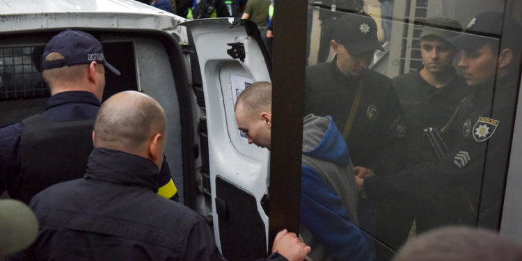 epa09968880 Russian serviceman Vadim Shishimarin (C) is escorted by police officers to a vehicle as he leaves after a court hearing in Kyiv, Ukraine, 23 May 2022. Russian serviceman Vadim Shishimarin, 21, was sentenced to life imprisonment for the killing of an unarmed 62-year-old civilian man near Chupakha village in the Sumy area in late February 2022. A court in Kyiv ruled on the day that Shishimarin has been found guilty of war crimes and handed a life sentence. Ukraine held the first war crimes trial amid the Russian invasion.  EPA-EFE/OLEG PETRASYUK