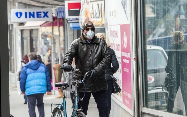 A man wear a mask  while rides a bicycle through a street in Skopje on December 4, 2018.
The World Health Organization listed Skopje as “the most polluted capital in Europe”. / AFP / Robert ATANASOVSKI