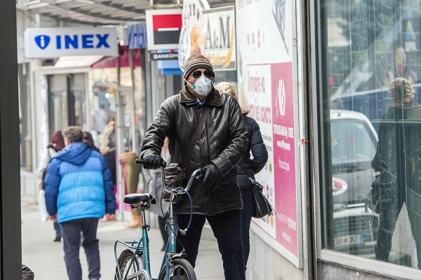 A man wear a mask  while rides a bicycle through a street in Skopje on December 4, 2018.
The World Health Organization listed Skopje as “the most polluted capital in Europe”. / AFP / Robert ATANASOVSKI